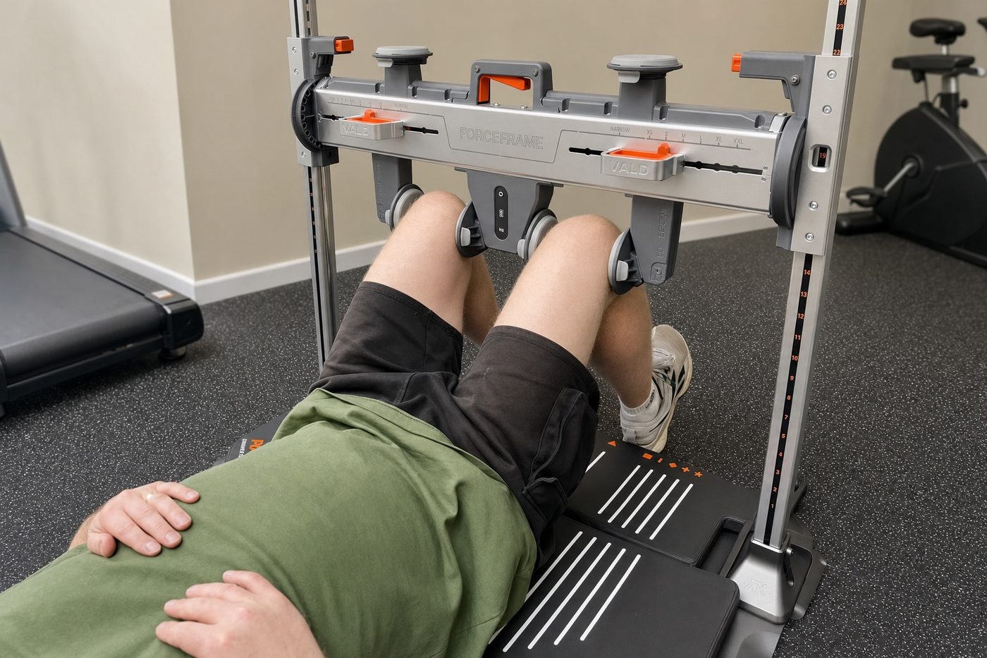A patient lying supine with both knees positioned in a VALD ForceFrame strength testing rig.
